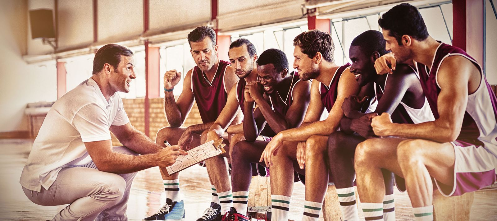 Coach explaining a game plan to college basketball players